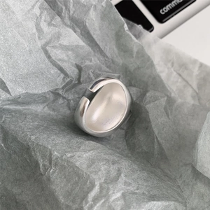 Detail of minimalist 925 sterling silver matte ring on crumpled paper background