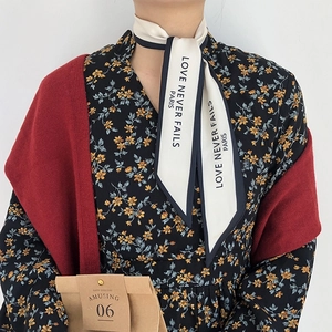 Detail of French vintage silk scarf with Love Never Fails text tied on model's hair