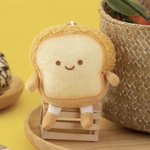 Close-up of a plush toast keychain with a cute embroidered smiling face and small feet