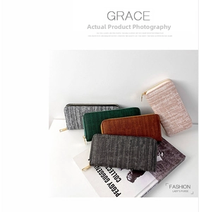 Close-up of long striped women's wallets in various colors with textured fabric and gold zipper