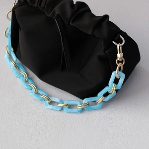 Detail of blue resin chunky chain with gold rings on black ruched cloud bag