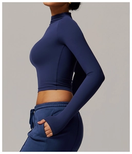 Side view of dark blue long sleeve compression crop top with high collar and stretch fabric