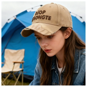 Detailed embroidery of DIOP SONGTE lettering on a vintage distressed khaki baseball cap