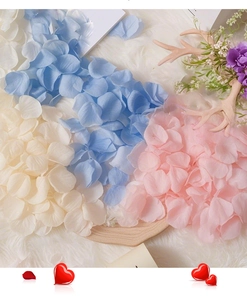 Blue, cream, and pink artificial rose petals scattered on soft white faux fur background