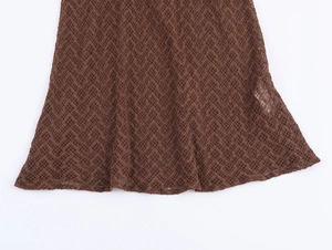 Macro view of dark brown knit fabric featuring an intricate diamond mesh lace pattern