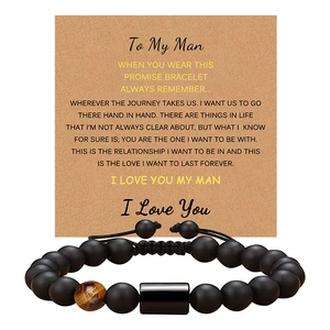 Detail of matte black beaded bracelet with tiger eye stone on a sentiment card for men