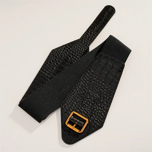Macro detail of black crocodile pattern belt with elastic band and gold metal buckle