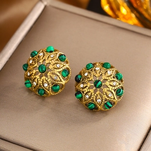 Vue macro de boucles d'oreilles vintage dorées avec perles malachite et strass scintillants