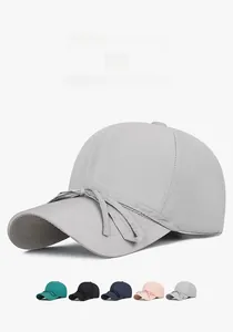 Detail of light grey quick-dry baseball cap featuring a decorative bow tie and breathable fabric