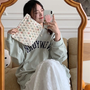 Mirror selfie showing floral cotton cosmetic bag in beige with colorful patterns