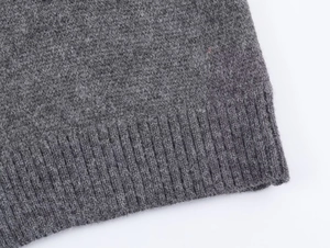 Detail of grey knitted fabric texture and ribbed hem on a two-piece sweater set
