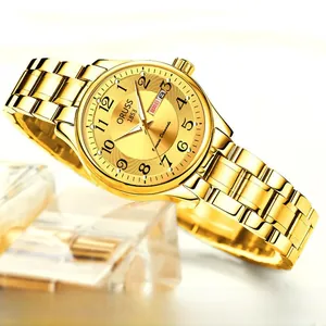 Détail d'une montre à quartz dorée avec double calendrier et index à chiffres arabes