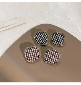 Detailed view of houndstooth square stud earrings with crystal borders on leather base