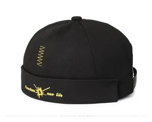 Close-up of yellow embroidery and leather back strap on black cotton miki hat