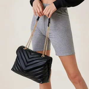 Women's black leather crossbody bag with V-shaped chevron quilting and gold chain strap