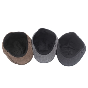 Detailed view of herringbone newsboy caps in brown and grey with classic inner lining