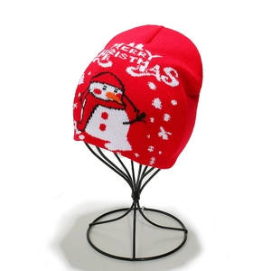 Detail view of red knitted Christmas beanie with white snowman and Merry Christmas text
