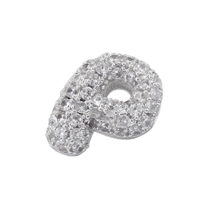 Macro detail of silver-toned letter P pendant with micro-pave cubic zirconia stones