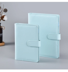 Light blue PU leather notebooks featuring a magnetic buckle closure in a still life view