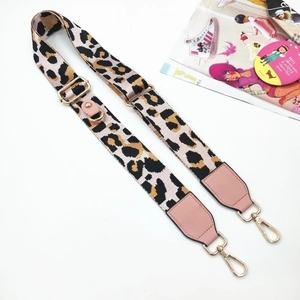 Detalle de correa de leopardo con cuero rosa y ganchos de metal dorado