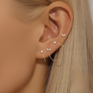 Macro shot of S925 sterling silver butterfly earrings with CZ tassels on model's ear
