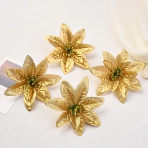 Close-up of four golden velvet poinsettia flowers with glitter and metallic finish