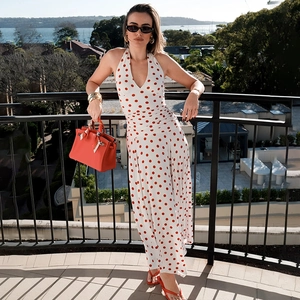 Detail of white halter neck jumpsuit with red polka dots and wide leg cut style