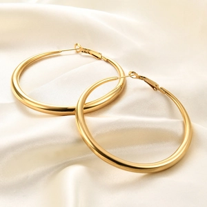 Classic 6mm golden hoop earrings for women on elegant white silk background