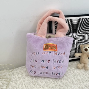 Détail du sac cabas en peluche violette avec anse rose et broderie colorée souple