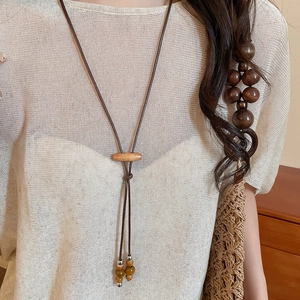 Close-up of bohemian wax rope necklace with ceramic beads and wood accents on a model
