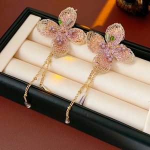 Detail of vintage flower earrings with pink beads and golden chain fringe on box
