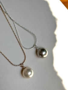 Detailed comparison of gray and cream pearls on minimalist silver and gold snake chains