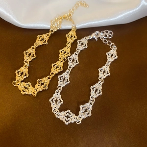 Detailed macro view of hollow heart pattern metal bracelets in gold and silver finishes