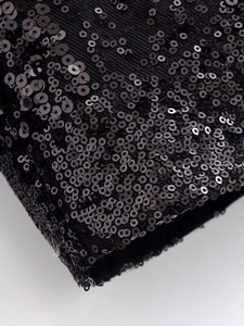 Close-up of black sequins on ribbed knit cuff detailing of the jacket's sleeve