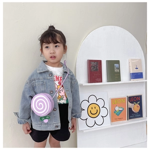 Close-up of child model wearing a purple lollipop-shaped crossbody bag with spiral patterns