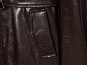 Close-up of the flap pocket and fine stitching on a vintage dark brown leather coat