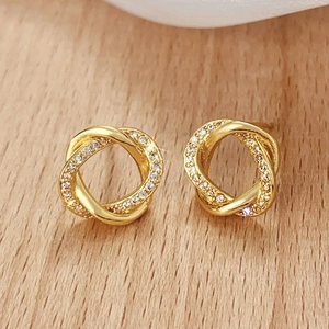Macro detail of gold knot earrings featuring sparkling pave-set cubic zirconia accents