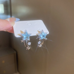 Detailed view of silver star earrings with blue zircon and elegant tassels