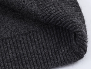 Detailed macro view of charcoal grey ribbed knit fabric with soft wool texture