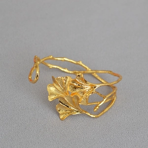 Detailansicht des goldenen Ginkgo-Blattes und der Zweigstruktur auf dieser Armspange