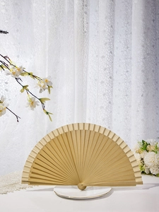 Macro shot of minimalist solid wood folding fan showing smooth natural wooden texture and ribs
