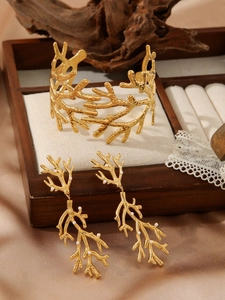 Détail d'un bracelet branche plaqué or 18 carats et boucles d'oreilles perles
