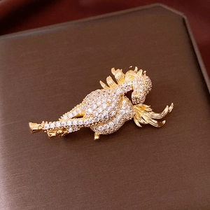 Macro view of a 14K gold-plated jumping horse brooch with pavé-set sparkling zircons