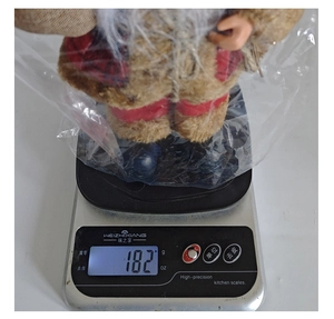 Standing Santa figurine weight measurement detail in red and grey plush fabric