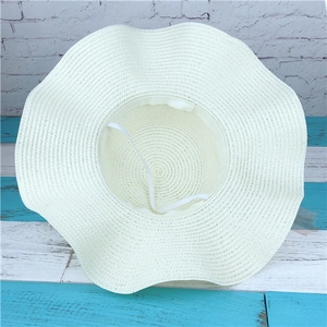 Detail view of woven sun hat interior with white elastic strap and wavy brim texture