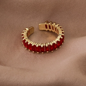 Detailed view of an adjustable gold ring set with sparkling red rectangular zircon stones