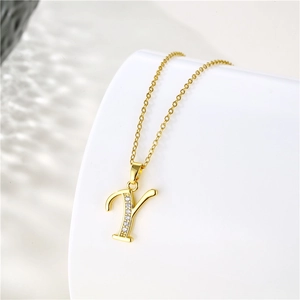 Close-up of a 18K gold letter Y pendant with clear crystals on an O-chain necklace