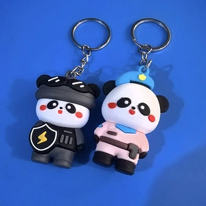 Detail of cute panda keychains in police and pink uniforms on a blue background