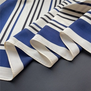 Close-up of blue and white striped silk satin scarf with smooth texture and fine stitching
