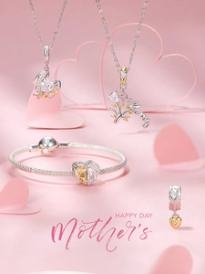 Detail of silver and gold heart pendants with Mom engraving for Mother's Day jewelry